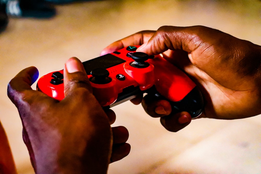Man with a red playstation controller on his hands.